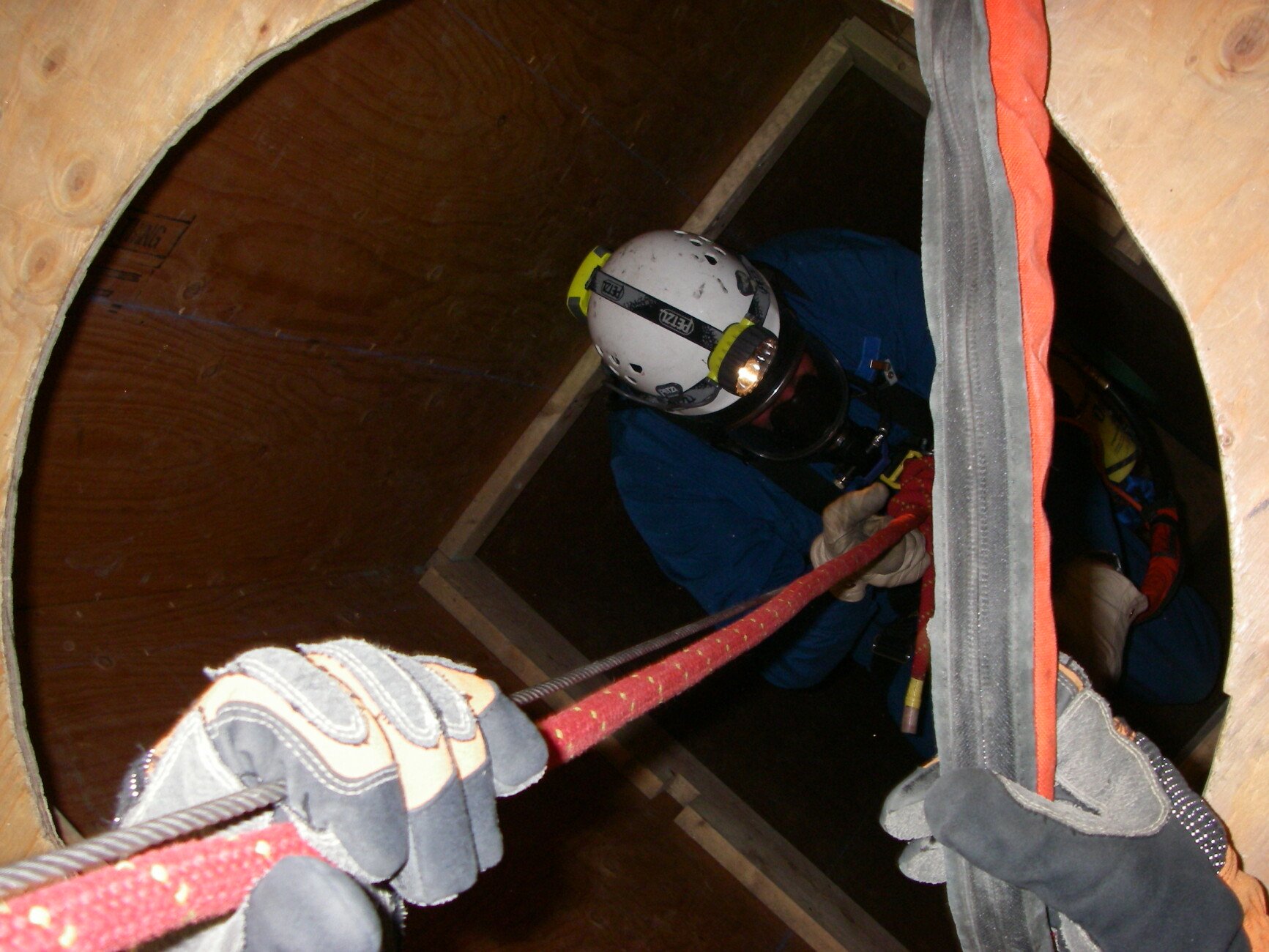 firefighter being lowered into hole