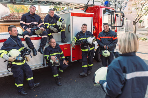 Group of male firefighters getting instructions from their female chief officer