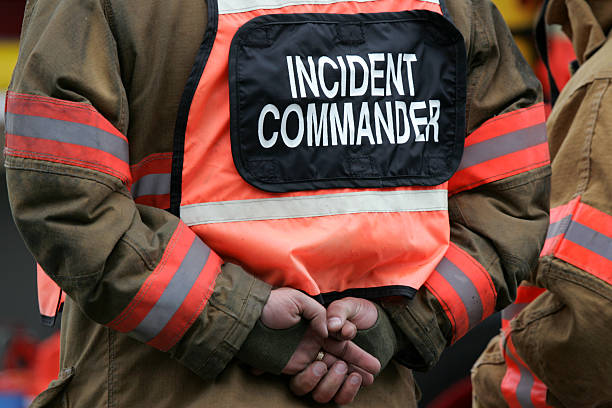 incident commander with hands clasped behind his back